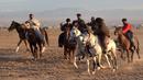 Penunggang kuda Afghanistan bersaing memperebutkan bangkai hewan dalam pertandingan Buzkashi di Herat, Afghanistan (4/2/2022). Buzkashi merupakan tradisi yang dilakukan oleh warga Afghanistan yang setiap pesertanya harus menunggang kuda. (AFP/Wakil Kohsar)