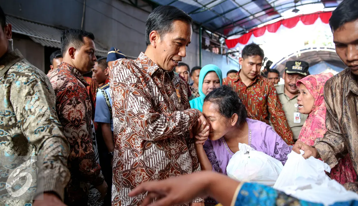 Presiden Joko Widodo didampingi Ibu Negara Iriana disambut warga saat blusukan ke Kedoya dan Petamburan, Jakarta, Selasa (1/9/2015). Selain sembako, Presiden Jokowi juga membagikan buku dan baju kepada anak-anak. (Liputan6.com/Faizal Fanani)