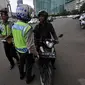 Aparat kepolisian lalu lintas saat memberhentikan pengendara motor gede yang menerobos Jalan MH Thamrin, Jakarta, Minggu (18/1/2015). (Liputan6.com/Miftahul Hayat)