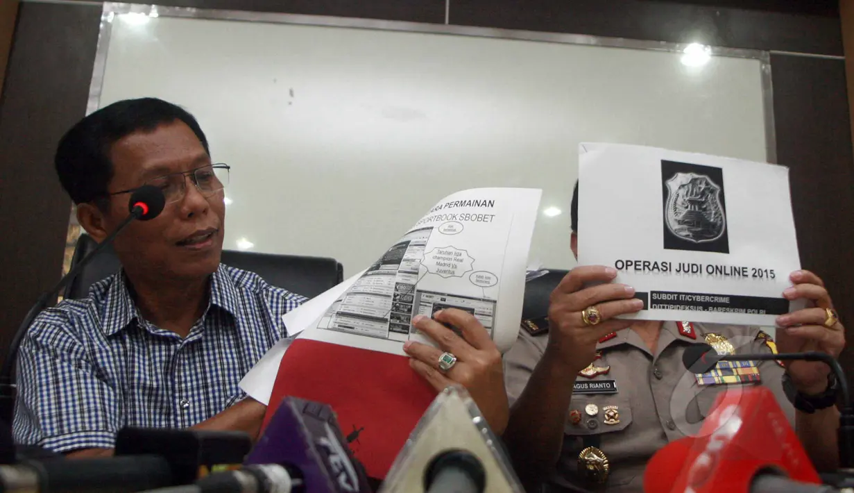 Direktur Tipideksus Bareskrim Brigjen Pol. Victor Edison Simanjuntak (kiri) dan Karopenmas,  Brigjen Pol. Agus Rianto memperlihatkan tampilan operasi judi online 2015 di Bareskrim Mabes Polri, Jakarta, Jumat (22/5/2015). (Liputan6.com/Helmi Afandi)