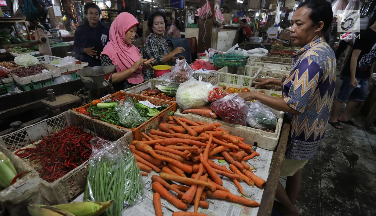 Pedagang melayani pembeli di pasar di Jakarta, Rabu (20/12).  Jelang Natal dan Tahun Baru, harga bahan pokok di Jakarta mulai merangkak naik. Namun, kenaikannya masih belum tinggi hanya berkisar Rp2.000-5.000 per kg. (Liputan6.com/Angga Yuniar)