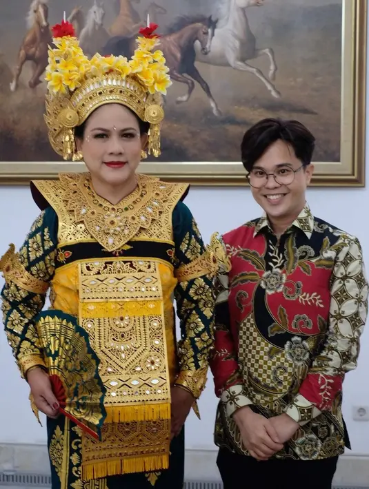 Penampilan Ibu Iriana semakin bak penari Legong Bali dengan kain penutup di bagian atasan. Kain yang digunakannya berwarna emas, serasi dengan aksesori yang dipakai Iriana. [Foto: Instagram/bennusorumba]