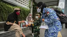 Perserta yang tergabung dalam Forum Kader Bela Negara DKI Jakarta membagikan bunga dan masker kepada warga di Jalan Thamrin, Jakarta, Rabu (22/12/2021). Aksi tersebut merupakan bentuk apresiasi terhadap kaum perempuan terutama pada peringatan Hari Ibu. (Liputan6.com/Faizal Fanani)