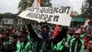 Pengemudi ojek online membentangkan poster saat menggelar aksi di seberang Istana Merdeka, Jakarta, Selasa (27/3). Mereka juga meminta legalitas angkutan ojek online. (Liputan6.com/Arya Manggala)