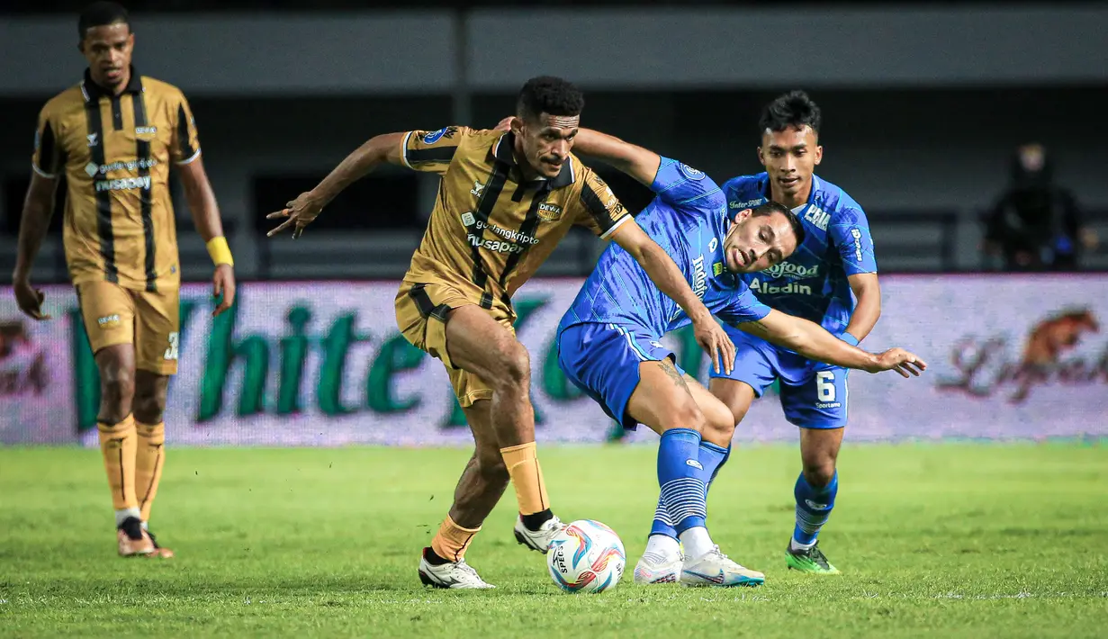 Pemain Persib Bandung, Ezra Walian (kanan), berebut bola dengan pemain Dewa United, Ricky Kambuaya, dalam pertandingan lanjutan pekan ketiga BRI Liga 1 2023/2024 yang berlangsung di Stadion Gelora Bandung Lautan Api, Jawa Barat, Jumat (14/7/2023). (Bola.com/Bagaskara Lazuardi)