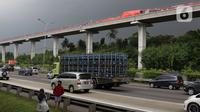 Kendaraan melintas di bawah kereta ringan lintas rel terpadu (LRT) Jabodebek yang mengalami kecelakaan di jalur lintas LRT Cibubur, Jakarta Timur, Senin (25/10/2021). Dua kereta LRT tersebut sedang uji coba saat tabrakan terjadi sehingga gerbong kosong. (Liputan6.com/Herman Zakharia)