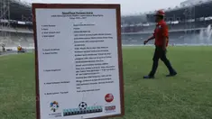 Pekerja melintas di depan papan spesifikasi rumput  di SUGBK, Senayan, Jakarta, Selasa (8/8/2017). SUGBK menggunakan rumput jenis Zoysia matrella yang merupakan rumput standar FIFA untuk stadion bertaraf internasional. (Bola.com/M Iqbal Ichsan)