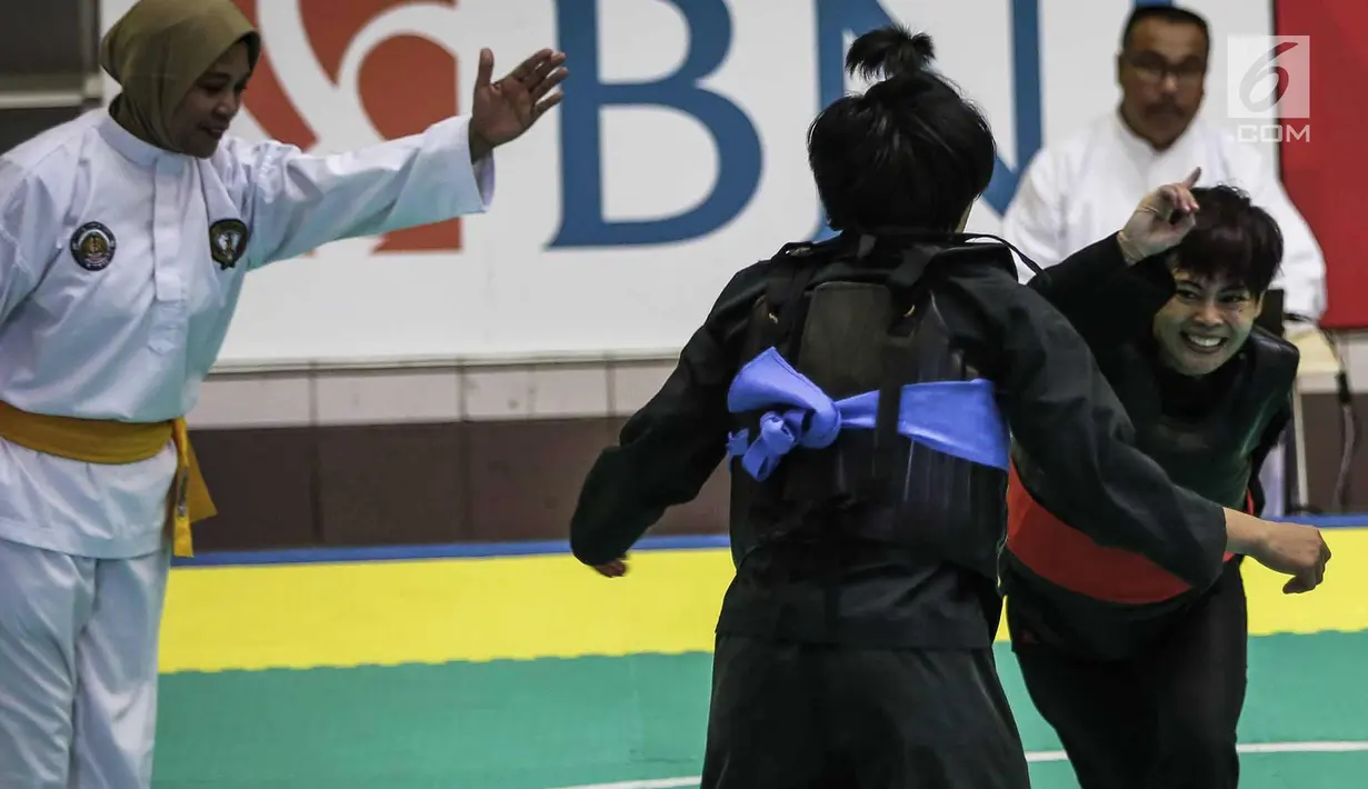 Pesilat Nirmalasari Oktaviani (kanan) beradu jurus dengan pesilat Laos Olathai Sounthavong di semifinal 50-55 kg putri cabang Pencak Silat 18th Asian Games Invitation Tournament, Jakarta, Senin (12/2). Indonesia menang 5-0. (Liputan6.com/Faizal Fanani)