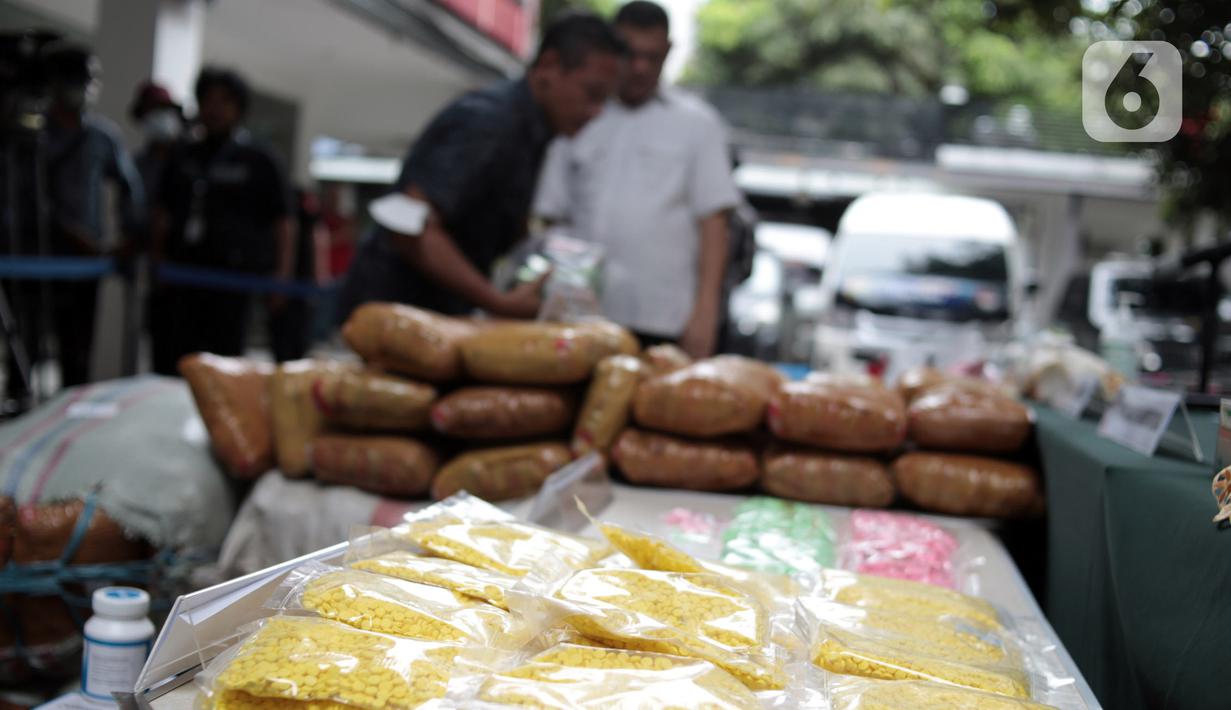 Petugas kepolisian menghadirkan barang bukti narkoba saat rilis hasil Operasi Kewilayahan Nila Jaya 2022 di Mapolda Metro Jaya, Jakarta, Selasa (13/12/2022). Direktorat Reserse Narkoba Polda Metro Jaya bersama Satuan Reserse Narkoba Polres berhasil mengamankan 278 tersangka dari 222 kasus serta barang bukti berupa 13,7 Kg sabu, 147,22 Kg ganja, 2.088 butir ekstasi, 229.759 butir obat baya, 119 gram tembakau sintetis, dan 1,17 liter cairan narkotika dalam Operasi Nila Jaya 2022 yang berlangsung 16-30 November 2022. (merdeka.com/Iqbal S. Nugroho)
