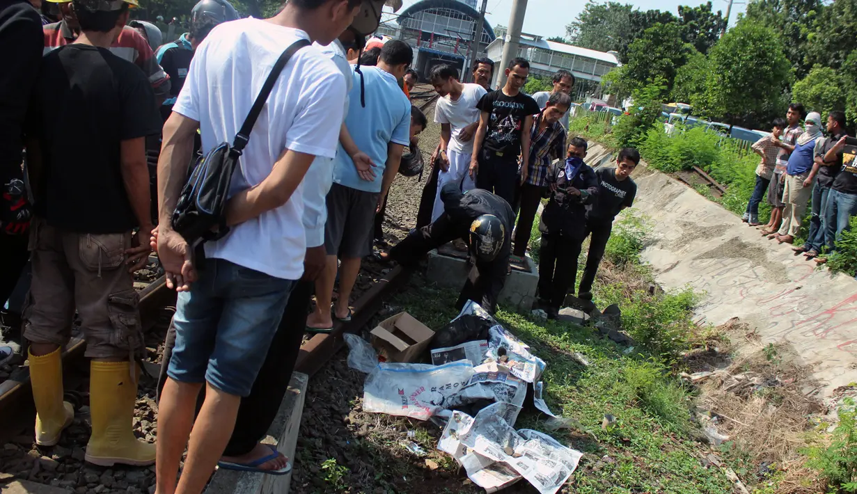 Seorang pria tewas tertabrak kereta api di Palmerah, Jakarta, Jumat, (8/5/2015). Puluhan warga tampak melihat jenazah korban yang tergeletak di pinggir rel. (Liputan6.com/JohanTallo)