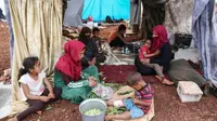 Para perempuan Suriah yang kehilangan tempat tinggal menyiapkan makanan di sebuah kamp sementara di provinsi Idlib yang dikuasai jihadis pada 23 Mei 2019. (AFP)