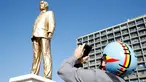 Warga mengabadikan patung emas raksasa PM Israel Benjamin Netanyahu di tengah-tengah Rabin Square, Tel Aviv, Selasa (6/12). Patung PM Israel ini telah menghebohkan seluruh warga setelah tiba-tiba muncul misterius sejak tadi malam. (REUTERS / Baz Ratner)