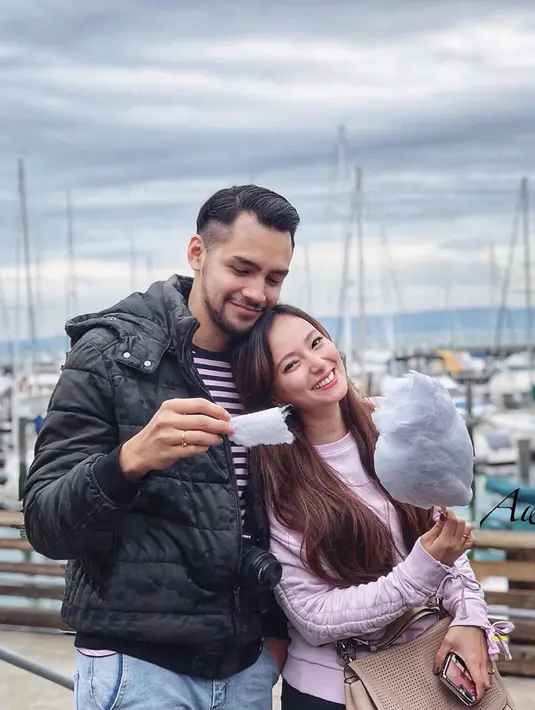 Penampilan pasangan sumai istri ini tetap mesra saat liburan ke luar negeri. Menggunakan pakaian dengan warna senada, keduanya tampak bahagia dengan permen kapas yang dipegang Asmirandah. (Liputan6.com/IG/@asmirandah89)