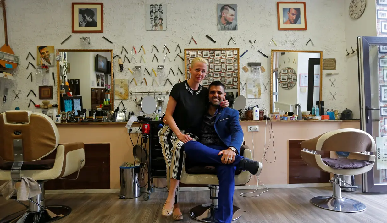 Ibrahim Haji Mohammad bersama sang istri Krisztina berpose berpose di dalam toko tempat cukur miliknya di Budapest, Hongaria, 24 Mei 2016. (REUTERS / Laszlo Balogh)
