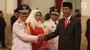 Presiden Joko Widodo atau Jokowi (kanan) menyalami Gubernur Riau Syamsuar saat pelantikan di Istana Negara, Jakarta, Rabu (20/2). Syamsuar dilantik menjadi Gubernur Riau periode 2019-2024. (Liputan6.com/Angga Yuniar)