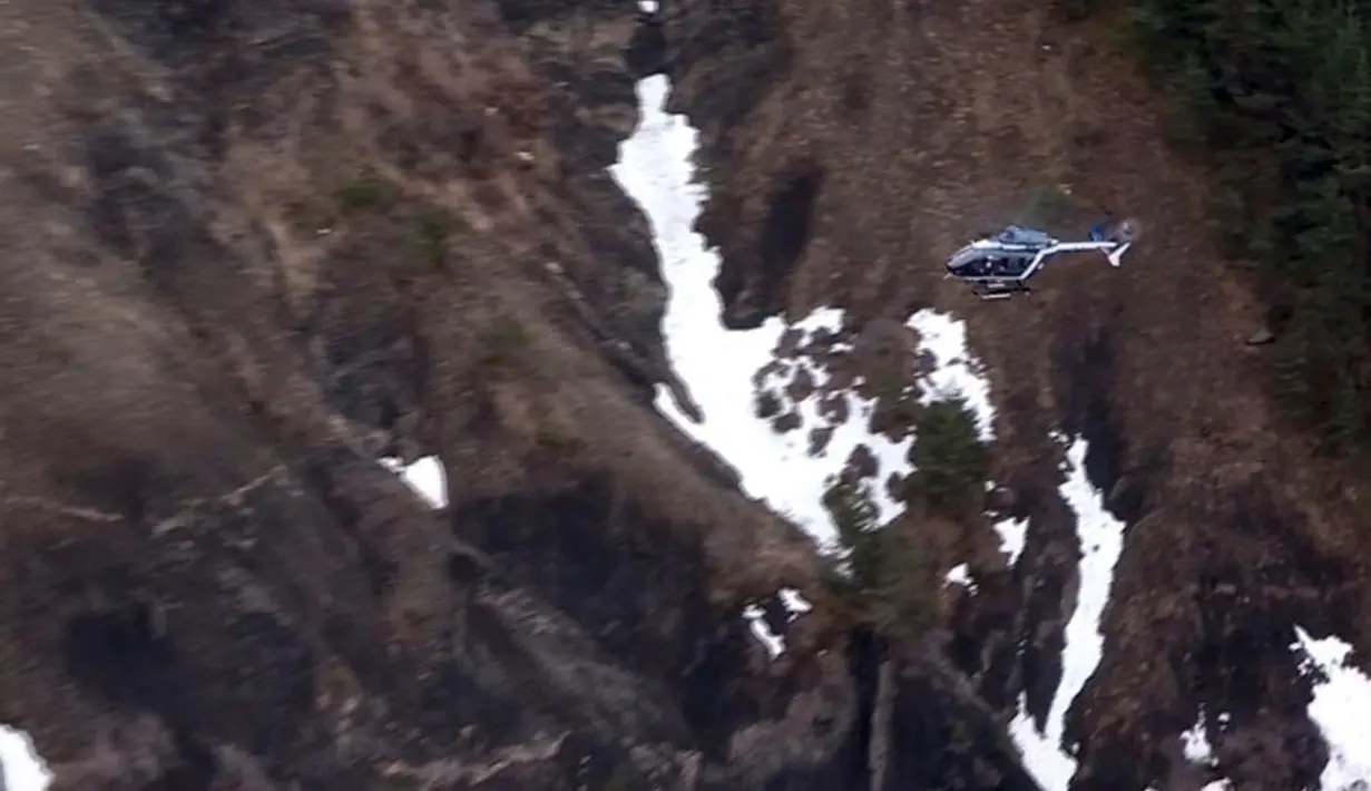 Sebuah helikopter penyelamat terbang di atas puing pesawat A320 Airbus Germanwings yang jatuh antara kota Barcelonnette dan Digne di Pegunungan Alpen Prancis, Selasa (24/3/2015). (AFP PHOTO /DENIS BOIS /GRIPMEDIA / AFP TV)