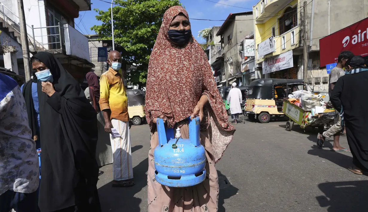 Seorang wanita Sri Lanka menunggu antrean isi ulang tabung gas memasaknya saat kekurangan pasokan di KolomboSelasa (4/1/2022). Antrean panjang selama berjam-jam telah menjadi pemandangan biasa dalam beberapa hari terakhir dalam upaya untuk membeli tabung gas domestik. (AP Photo/Eranga Jayawardena).