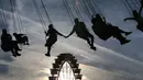 Pasangan kekasih berpegangan tangan saat menaiki komedi putar di festival bir terbesar di dunia Oktoberfest ke-185, Munich, Jerman, Sabtu (22/9). (Karl-Josef Hildenbrand/dpa /AFP)