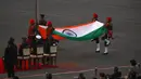 Tentara India melipat bendera nasional saat matahari terbenam selama upacara Beating Retreat di Raisina Hills, pusat kekuasaan pemerintah, New Delhi, India, Jumat (29/1/2021). Upacara tersebut menandai akhir dari perayaan Hari Republik tahunan. (AP Photo/Manish Swarup)