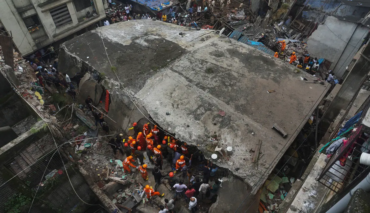 Tim penyelamat menyisir puing-puing beton serta batu bata untuk mencari korban setelah runtuhnya bangunan tempat tinggal tiga lantai di Bhiwandi, India, Senin (21/9/2020). Hingga saat ini, otoritas India belum mengumumkan penyebab pasti terjadinya insiden bangunan roboh. (AP Photo/Praful Gangurde)