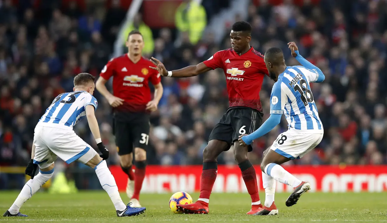 Gelandang Manchester United, Paul Pogba, berusaha melewati pemain Huddersfield pada laga Premier League di Stadion Old Trafford, Rabu (26/12). Manchester United menang 3-1 atas Huddersfield. (AP/Martin Rickett)