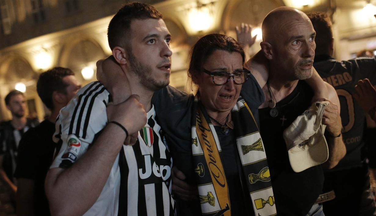 Seorang wanita dievakuasi usai terjadi ledakan saat nonton bareng final Liga Champions di Piazza San Carlo, Turin, Sabtu (3/6/2017). Acara nobar dipadati sekitar 20.000 supporter Juventus. (AFP/Marco Bertorello)