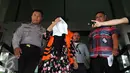 Komisaris CV Timur Alam Raya, Sri Astuti menutupi wajah usai menjalani pemeriksaan di KPK, Jakarta, Senin (22/8). Sri Astuti diduga melakukan penyuapan terkait pengadaan pupuk urea di PT Berdikari tahun anggaran 2010-2012. (Liputan6.com/Helmi Afandi)