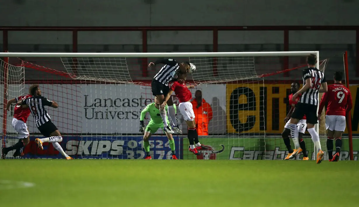 Pemain Newcastle United Jamaal Lascelles (tengah) mencetak gol ke gawang Morecambe pada pertandingan Piala Liga Inggris di The Globe Arena, Morecambe, Inggris, Rabu (23/9/2020). Newcastle United mengalahkan Morecambe dengan skor 7-0. (Martin Rickett/Pool Photo via AP)