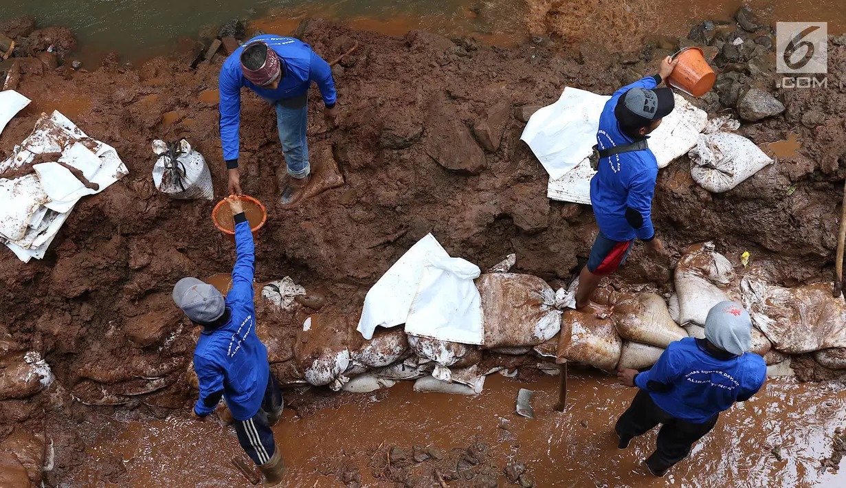 Petugas membongkar dinding turap di saluran air kawasan Pancoran, Jakarta, Senin (28/1). Pembongkaran dilakukan untuk mengganti batu penahan turap guna mencegah kelongsoran selama musim hujan. (Liputan6.com/Immanuel Antonius)