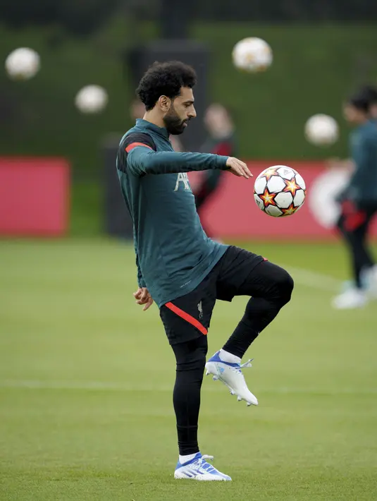 <p>Penyerang Liverpool, Mohamed Salah menjugling bola saat mengikuti sesi latihan di AXA Training Centre, Liverpool, Inggris, Selasa (26/4/2022). Liverpool akan bertanding melawan wakil Spanyol, Villarreal pada leg pertama semifinal Liga Champions di Stadion Anfield, Kamis (28/4/2022) dini hari WIB. (Peter Byrne/PA via AP)</p>