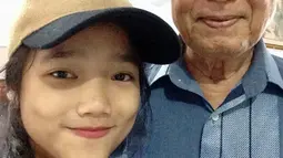 Di foto lain, Fuji yang kini beranjak dewasa berdiri di samping sang kakek yang sudah menua. Meski pikun dan menderita Parkinson, kebersamaan itu mengobati rindunya meski sang kakek tak lagi mengingat dirinya. (Liputan6.com/IG/@fuji_an)