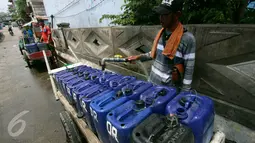 Penjual air mengisi air bersih di Jakarta, Rabu (30/11). Air yang dijual 10 ribu per dirigen tersebut banyak dibutuhkan warga yang tinggal di pesisir Jakarta dikarenakan sulitnya mendapatkan air bersih. (Liputan6.com/Angga Yuniar)