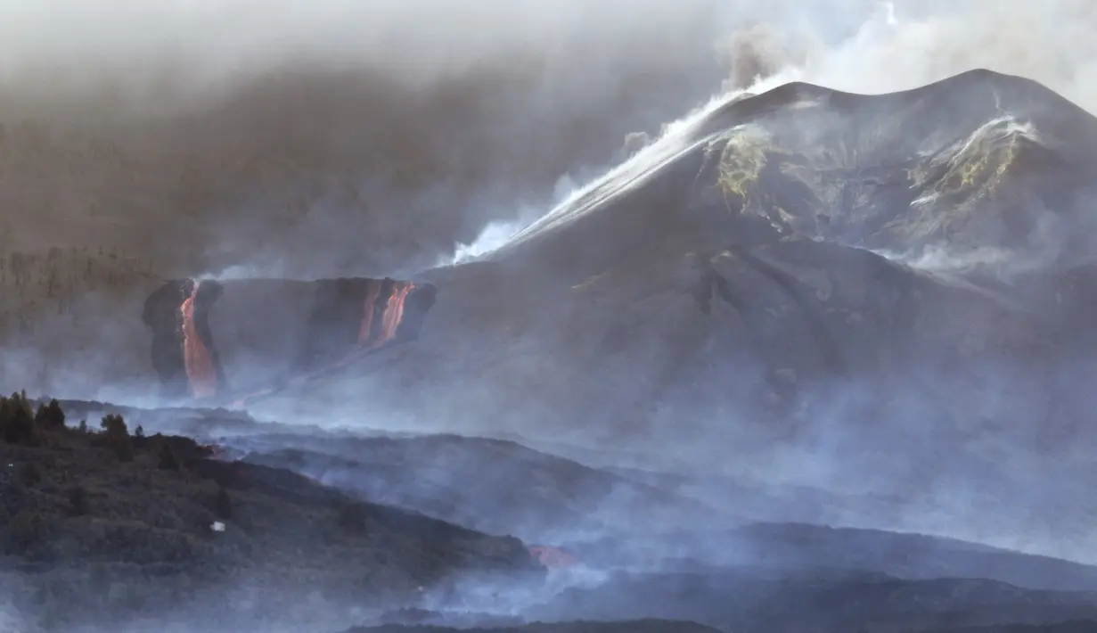 Lahar mengalir saat gunung berapi terus meletus di pulau Canary La Palma, Spanyol, Senin (29/11/2021). Punggung bukit dan mengancam akan memperluas dampak pada tanah yang dievakuasi, infrastruktur dan rumah. (AP/Emilio Morenatti)