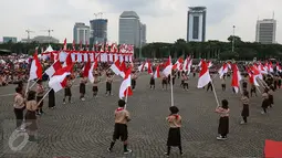 Sejumlah siswa membawa bendera merah putih saat acara Nusantara Bersatu di Monas, Jakarta, Rabu (30/11). Sekitar 40.000 orang hadir dalam acara tersebut, dengan mengenakan pita merah putih yang diikatkan di kepala. (Liputan6.com/Johan Tallo)