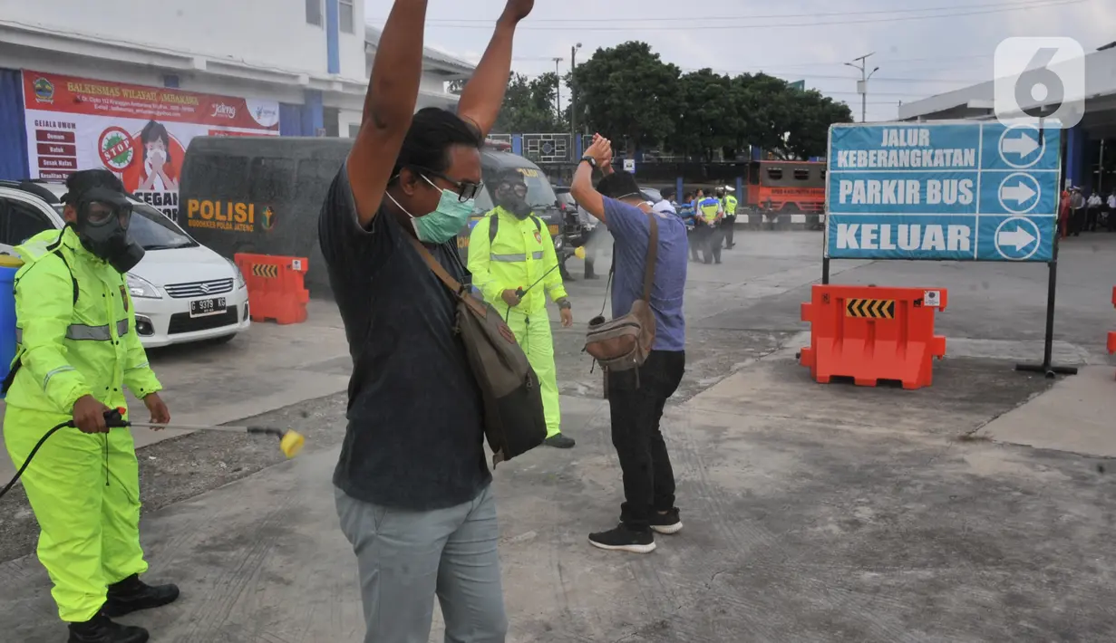 Calon penumpang disemprot disinfektan saat sterilisasi puluhan angkutan bus yang masuk di Terminal Bawen, Jumat (27/3/2020).  Sterilisasi dilakukan dengan menyemprotkan cairan disinfektan ke armada dan para penumpang yang turun di terminal tersebut. (Liputan6.com/Gholib)