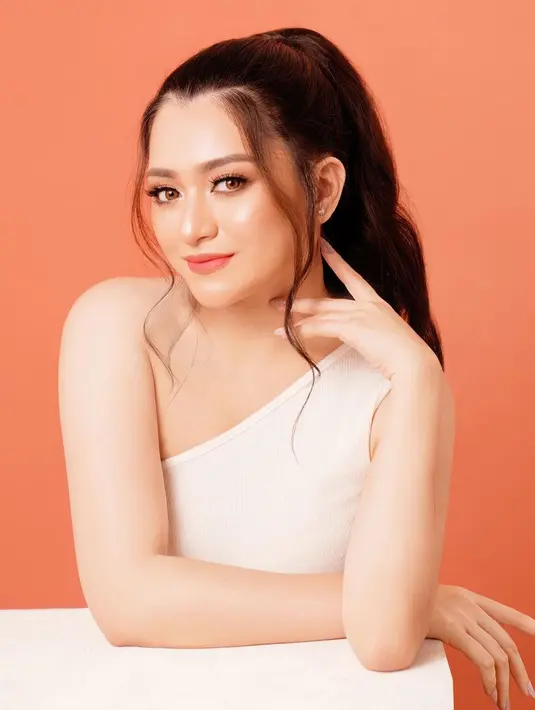 Nathalie Holscher menghadirkan makeup bernuansa merah muda dengan paduan highlighter yang membuat penampilannya semakin bercahaya. Rambutnya ditata high-ponytail dan menyisakan beberapa helai sebagai poni di sisi kanan-kiri wajahnya. Foto: Instagram.