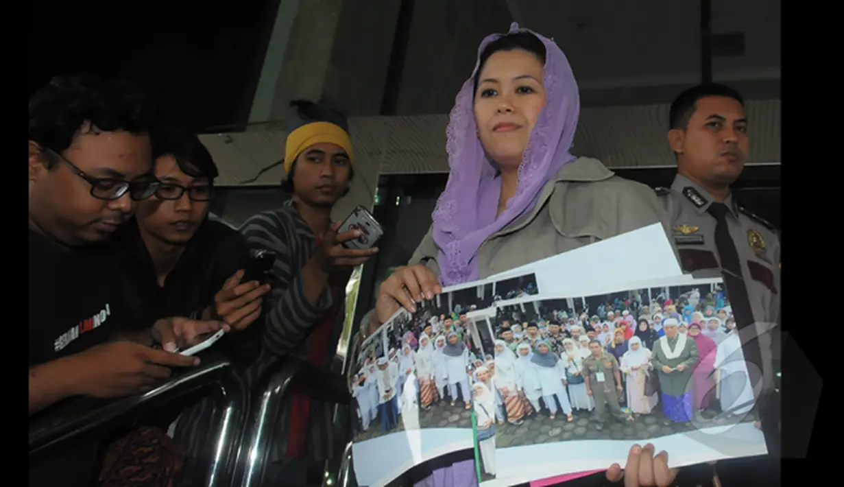 Yenny Wahid menunjukkan foto - foto pada wartawan di depan Gedung Komisi Pemberantasan Korupsi, Jakarta, Kamis (12/2/2015). Yenny Wahid menyampaikan titipan dukungan warga pesantren di jawa barat. (Liputan6.com/Herman Zakharia)