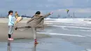 Seorang wanita melemparkan bunga ke laut sebagai penghormatan kepada para korban gempa bumi dan tsunami 2011 di daerah Arahama, Kota Sendai, Jepang, Rabu (11/3/2020). Gempa 9,0 magnitudo yang menyebabkan tsunami pada 11 Maret 2011 itu menyebabkan sekitar 15 ribu orang tewas. (Kyodo News via AP)