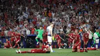 Pemain Tottenham Hotspur Harry Kane berjalan melewati pemain Liverpool yang sedang merayakan kemenangan di final Liga Champions di Stadion Wanda Metropolitano, Madrid, Spanyol, Sabtu (1/6/ 2019). (AP Photo/Felipe Dana)