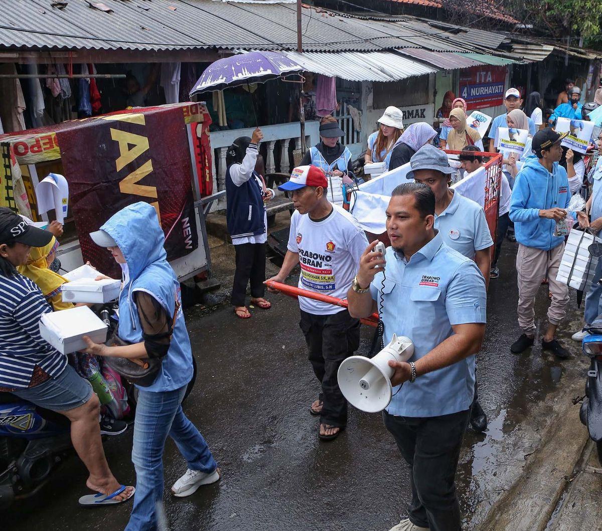 Relawan Laskar Prabowo 08 DKI Jakarta membagikan 500 paket makanan, susu, dan kacang hijau gratis kepada warga di Bojong Indah, RW 06, Duren Sawit, Jakarta Timur, Jumat (19/01/2024). Menjelang Pilpres 2024 pada 14 Februari 2024, relawan Prabowo-Gibran men