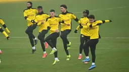 Para pemain Borrusia Dortmund melakukan pemanasan selama sesi latihan di tempat latihan tim di Dortmund, Jerman barat (9/3/2021). Dortmund akan bertanding melawan Sevilla pada leg kedua babak 16 besar Liga Champions di Signal Iduna Park. (AFP/Ina Fassbender)