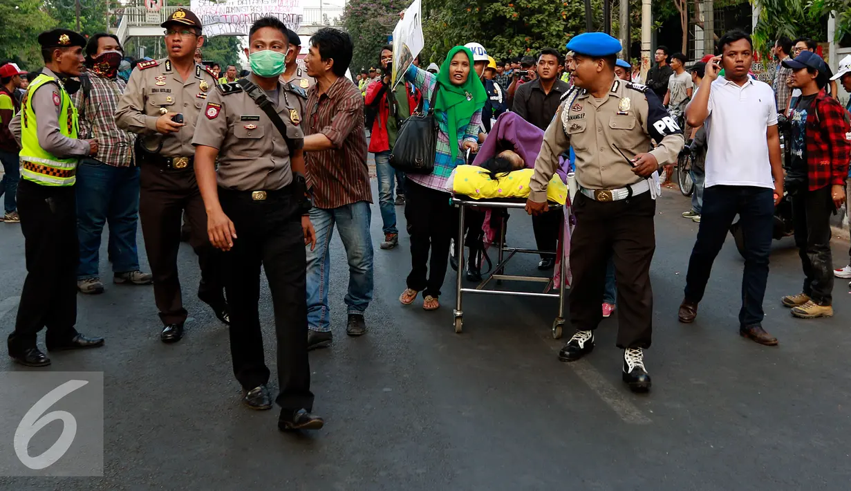 Pasien RSCM ditandu menggunakan bed berdoa milik rumah sakti karena mobil ambulans tertahan oleh aksi demo mahasiswa UPI YAI, Dipenogoro, Jakarta, Selasa (27/10/2015). (Liputan6.com/Yoppy Renato)