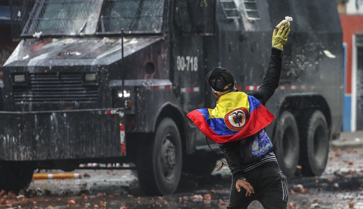 Seorang pengunjuk rasa anti-pemerintah melemparkan sekantong cat ke kendaraan polisi selama bentrokan di Madrid, di pinggiran Bogota, Kolombia (28/5/2021). (AP Photo/Ivan Valencia)
