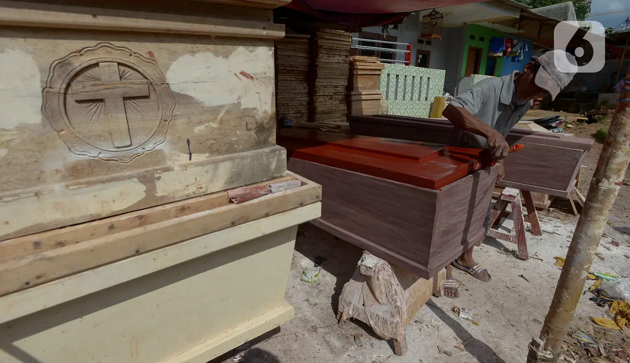Herman pengrajin peti mati sedang mengecat pelitur untuk pembuatan peti mati di Pondok Kelapa, Jakarta Timur, Rabu (6/5/2020). Peti untuk jenazah Covid-19, terbuat dari aluminium foil dengan harga Rp 900 ribu untuk ukuran dewasa dengan panjang sekitar 100-200 cm. (merdeka.com/Imam Buhori)