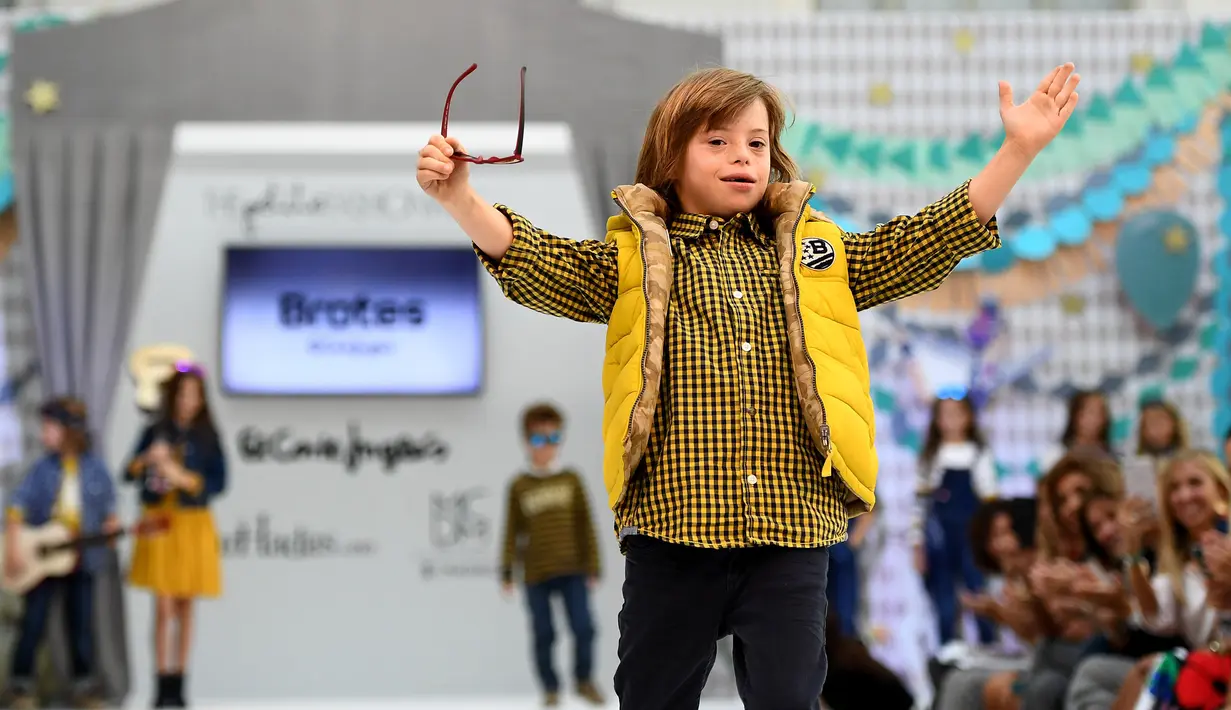 Seorang anak laki-laki dengan down syndrome ambil bagian di atas catwalk pekan mode Petite Fashion Week di Madrid, 6 Oktober 2017. Model mungil itu berasal dari Garrigou Foundation, tempat pendidikan untuk anak-anak berkebutuhan khusus (GABRIEL BOUYS/AFP)