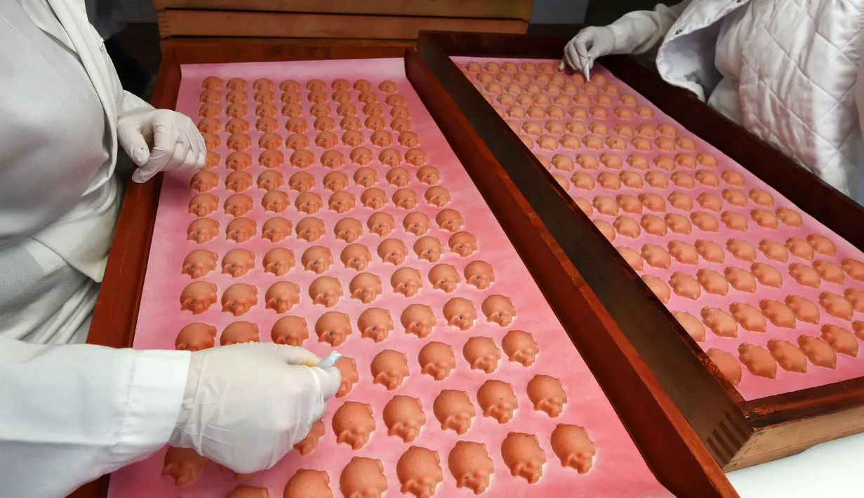 Cetakan kue yang berbentuk babi yang hampir selesai dibuat di tempat pembuatan tradisional JG Niederegger GmbH di Luebeck, Jerman (5/12). Luebeck Marzipan juga biasa disebut Luebecker Marzipan atau hanya Luebecker saja. (AFP Photo/Stollarz)