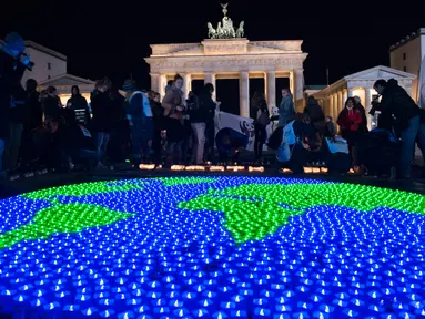 Sejumlah lilin dinyalakan dan dibentuk seperti dunia sebelumnya aksi Earth Hour Internasional di Berlin, Jerman (25/3). Kegiatan ini dilakukan dalam rangka memperingati hari bumi atau lebih dikenal dengan Earth Hour ke-10 atau 2017. (AFP/dpa/Paul Zinken)