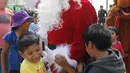 Seorang polisi Peru berpakaian seperti Santa Claus bermain dengan anak-anak selama perayaan Natal di Huaycan, Lima, Peru (15/12/2015). (REUTERS/Janine Costa)