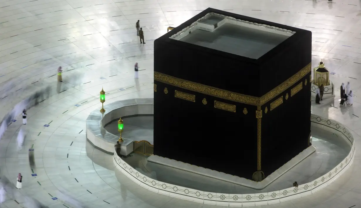 Dalam foto yang diambil dengan kecepatan rana lambat ini menunjukkan jemaah umrah menerapkan jaga jarak untuk membantu mengekang penyebaran virus corona COVID-19 saat tawaf mengelilingi Ka'bah di Masjidil Haram, Mekkah, Arab Saudi, Senin (12/4/2021). (AP Photo/Amr Nabil)