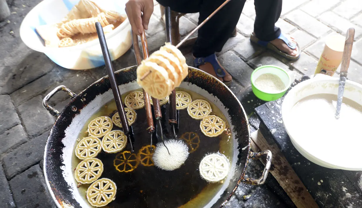 Pekerja menggoreng jajanan tradisional kembang goyang di Kelurahan Karangan, Setu, Tangerang Selatan, Banten, Kamis (6/8/2020). Jajanan kue kering berbentuk bunga tersebut dijual dengan harga Rp 5 ribu per bungkus. (merdeka.com/Dwi Narwoko)